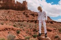 A curly haired blonde man posing around the famous Buttes of Monument Valley from Arizona, USA, wearing white linen shirt and Royalty Free Stock Photo