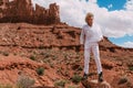 A curly haired blonde man posing around the famous Buttes of Monument Valley from Arizona, USA, wearing white linen shirt and Royalty Free Stock Photo