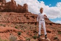 A curly haired blonde man posing around the famous Buttes of Monument Valley from Arizona, USA, wearing white linen shirt and Royalty Free Stock Photo