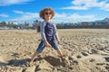 Curly haired boy posing on the beach