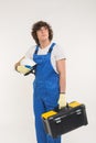 Construction, building and workers concept - Curly haired builder lifting up toolbox and white helmet in studio.