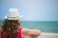 Curly haired girl at ocean coast. Rear view. Royalty Free Stock Photo