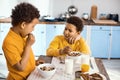 Curly-haired little boys chatting while eating cereals Royalty Free Stock Photo