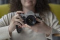 Curly haired photographer woman holding her camera in a cafe and shooting Royalty Free Stock Photo