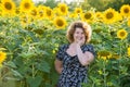 Curly-haired woman in field of sunflowers Royalty Free Stock Photo