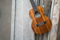 Curly koa ukulele gloss finished against wooden background. Royalty Free Stock Photo