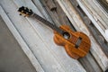 Curly koa ukulele gloss finished against wooden background. Royalty Free Stock Photo