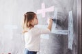 Curly little baby girl drawing with crayon color on the wall. Works of child. Cute pupil writing on chalkboard Royalty Free Stock Photo