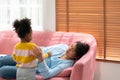 Curly small child daughter with stethoscope listening heartbeat of her mother, playing doctor and patient game in living room Royalty Free Stock Photo