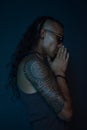 A curly long hair man meditating and praying feeling peace, thankful in his soul, mindfulness experience, black background