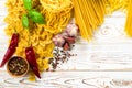 curly pasta with pepper and basil and seasoning on the table, different varieties of pasta