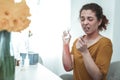 Curly red-haired woman with reddening on arm taking pill Royalty Free Stock Photo