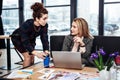 Curly secretary bringing some hot coffee for her demanding female boss