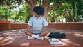 Curly student looking laptop screen sitting park. African woman studying online Royalty Free Stock Photo