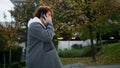 Curly teen calling phone street closeup. Young man walking stairs in autumn park Royalty Free Stock Photo