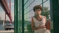 Curly teenager posing metal grid portrait. Basketball guy looking camera stadium