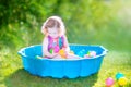 Curly toddler girl playing wil balls in the garden Royalty Free Stock Photo