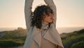 Curly woman evening sunlight stretching closeup. Thoughtful girl admire ocean