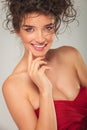 Curly woman in red dress smiling Royalty Free Stock Photo