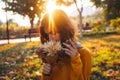 Curly young girl in yellow sweater on grass with autumn bouquet of dry leaves and flowers Royalty Free Stock Photo