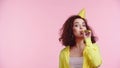 curly young woman blowing party horn Royalty Free Stock Photo