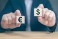 Currency concept. businessman`s hands hold two wooden cubes with dollar and euro sign. businessman chooses euro or dollar signs Royalty Free Stock Photo