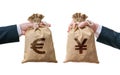 Currency exchange concept. Hands holds bags full of money - Euro and Yen Royalty Free Stock Photo