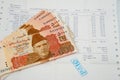 Currency notes in Pakistani Rupees with a paid invoice