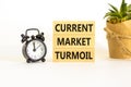 Current market turmoil symbol. Concept words Current market turmoil on wooden blocks on a beautiful white table white background. Royalty Free Stock Photo