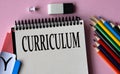 CURRICULUM - a word written in a notebook on a pink background and colored pencils Royalty Free Stock Photo