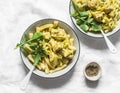 Curried creamy salmon with pasta on a light background, top view