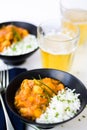 Curry chicken on black bowls and beer