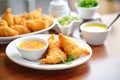 curry puffs on a plate with dipping sauce