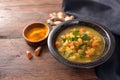 Curry soup with vegetables, turmeric and ginger in a dark bowl on a rustic wooden table with copy space, selected focus Royalty Free Stock Photo