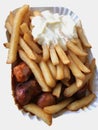 Currywurst & Pommes on white background: Famous German Fast Food Curry Sausage with French Fries and Curry Sauce Royalty Free Stock Photo