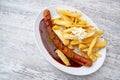 Currywurst, popular fast food in Germany consisting of sausage with curry ketchup, served with French fries and mayonnaise on an Royalty Free Stock Photo