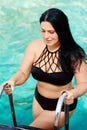 A curvaceous girl on the ladder of the boat