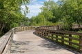 Curve ahead on an empty elevated boardwalk running through forest and wetlands, public use walking trail Royalty Free Stock Photo