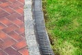 Curve iron gutter with grate to the drainage system on the side of the walkway.