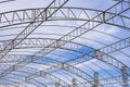 Curve lines pattern of metal roof beam structure of large dome event tent against clouds on blue sky background Royalty Free Stock Photo