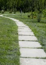 The curve the path of concrete tiles on a Sunny day.Park with a long road along the trees.Park with a long road along the trees. T Royalty Free Stock Photo