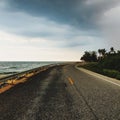 Curve road beside seashore against dark sky Royalty Free Stock Photo