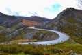 Curved asphalt road in middle of a rocky mountain. Dangerous s-shaped way