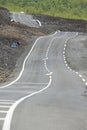 Curved asphalt road over volcanic lava, Reunion island, France.