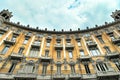 Curved baroque style residential building exterior view from below under cloudy sky