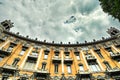 Curved baroque style residential building exterior view from below under cloudy sky