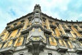 Curved baroque style residential building exterior view from below under cloudy sky