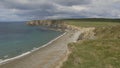 curved beach surrounded by cliffs with powerful clouds . Kilfarrasy Beach. Co.Waterford Coastline, Ireland