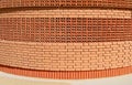 Curved brick wall with rows of bricks arranged in different pattern.