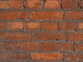 Curved brickwork made of red orange shine golden geometric horizontal bricks bonded with cement grout between square Royalty Free Stock Photo